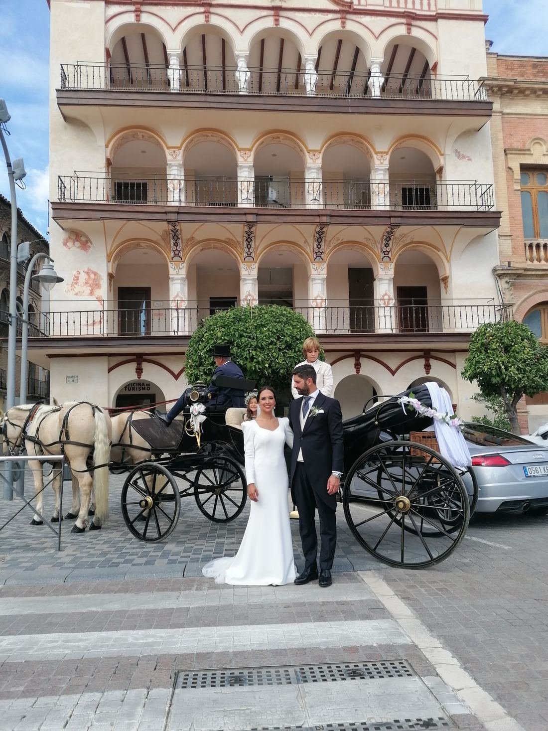Novios junto al carruaje en una plaza de Andalucía